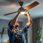 A photograph of a skilled lighting contractor installing a ceiling fan dimmer switch in a modern home setting