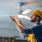 A photograph of a skilled lighting contractor installing a stylish fan-in light fixture in a modern home setting