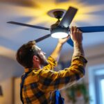 A photograph of a lighting contractor skillfully installing or adjusting a stylish ceiling fan with integrated lighting in a modern home setting