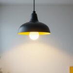 A photograph of a stylish black and white hanging light fixture in a modern interior setting