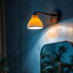 A photograph of a stylish industrial vanity light fixture installed in a modern bathroom setting