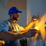 A photograph of a lighting contractor skillfully installing plug-in can lights in a modern living space