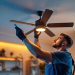 A photograph of a skilled lighting contractor installing a stylish ceiling fan in a modern home setting