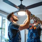 A photograph of a skilled lighting contractor expertly replacing a fan light cover in a modern home setting