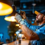 A photograph of a skilled lighting contractor expertly installing or adjusting modern lighting fixtures in a vibrant commercial space