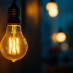 A photograph of a vintage light bulb glowing softly in a dimly lit room