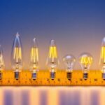 A photograph of a variety of candelabra bulbs displayed alongside a measuring tape or ruler
