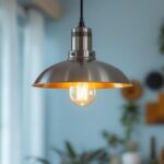 A photograph of a stylish stainless steel pendant light hanging in a modern interior setting