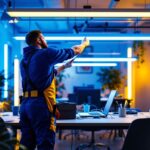 A photograph of a lighting contractor installing vibrant commercial led light strips in a dynamic workspace