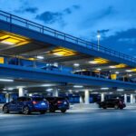 A photograph of a well-lit parking structure at dusk