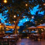 A photograph of a beautifully illuminated outdoor restaurant setting at dusk