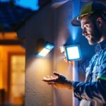 A photograph of a lighting contractor installing a state-of-the-art security motion light in a residential setting