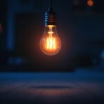 A photograph of a glowing incandescent light bulb in a dimly lit setting