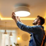 A photograph of a skilled lighting contractor installing modern ceiling lights in a stylish residential space