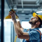 A photograph of a lighting contractor expertly installing a surface mount fixture in a modern