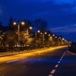 A photograph of a well-lit urban roadway at dusk