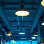 A photograph of a modern office space illuminated by various ceiling lamps