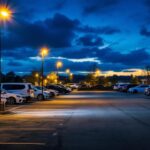 A photograph of a well-lit parking lot at dusk