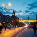 A photograph of a vibrant urban street scene illuminated by led street lights at dusk