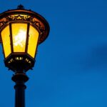 A photograph of a beautifully illuminated lamp post at dusk
