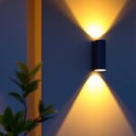 A photograph of a beautifully illuminated outdoor space featuring solar light sconces installed on a stylish wall
