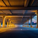 A photograph of a well-lit outdoor parking garage at dusk