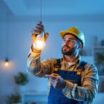 A photograph of a lighting contractor installing a 14w led bulb in a modern residential setting
