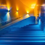 A photograph of a well-lit stairway featuring various lighting options