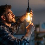 A photograph of a skilled lighting contractor expertly installing or adjusting a stylish hanging bulb in a well-designed space