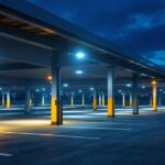 A photograph of a well-lit car parking area at dusk
