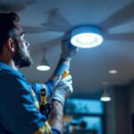 A photograph of a lighting contractor skillfully retrofitting an led canister in a modern ceiling
