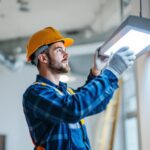 A photograph of a lighting contractor installing or examining a sleek