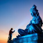 A photograph of a beautifully illuminated statue at dusk
