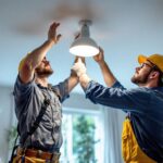 A photograph of a skilled lighting contractor carefully relocating a ceiling light fixture in a well-lit room