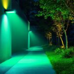 A photograph of a modern lighting installation showcasing a vibrant green floodlight illuminating an outdoor space