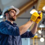 A photograph of a skilled lighting contractor expertly installing or adjusting lighting fixtures in a modern space