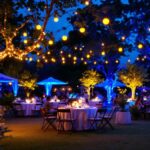 A photograph of a beautifully arranged outdoor setting illuminated by vibrant ultraviolet string lights