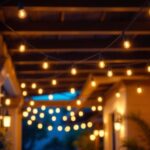 A photograph of a beautifully lit overhead porch showcasing stylish outdoor lighting fixtures