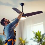 A photograph of a lighting contractor installing an unconventional ceiling fan in a stylish interior space
