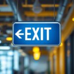 A photograph of a well-lit exit sign made of metal