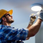 A photograph of a lighting contractor skillfully installing led can trims in a modern residential space