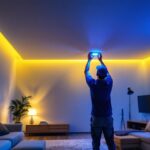 A photograph of a lighting contractor installing motion sensor ceiling lights in a modern residential setting