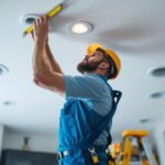 A photograph of a lighting contractor measuring the ceiling in a home
