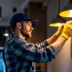 A photograph of a skilled electrician or technician expertly installing modern lighting fixtures in a stylish interior space