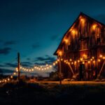 A photograph of an old barn illuminated by vintage-style lights