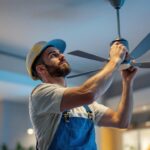 A photograph of a lighting contractor expertly installing or adjusting a stylish cilen fan in a modern