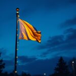 A photograph of a well-lit flagpole at dusk