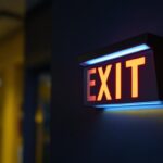 A photograph of a well-lit emergency exit sign integrated with a sleek emergency light in a commercial setting