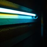 A photograph of a close-up shot of a flickering fluorescent tube in a dimly lit environment
