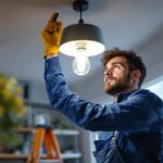 A photograph of a lighting contractor expertly installing a modern lighting fixture in a residential setting